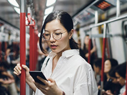 Questions about foreign Earned Income? Ask Scott Nissen, Tax and Accounting. Woman reading a device on a bus in a foreign country.