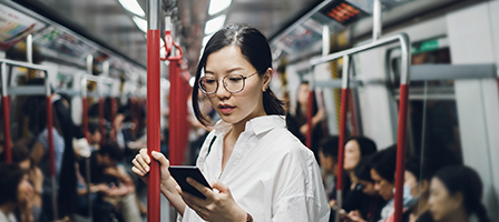 Questions about foreign Earned Income? Ask Scott Nissen, Tax and Accounting. Woman reading a device on a bus in a foreign country.