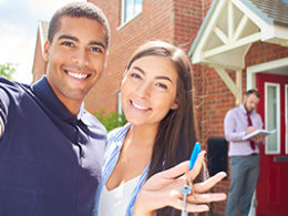 smiling couple holding the keys to their new rental