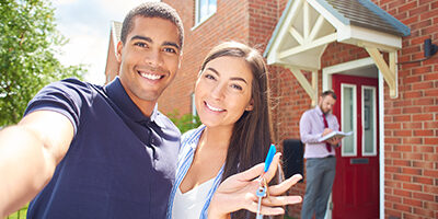 smiling couple holding the keys to their new rental