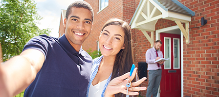 smiling couple holding the keys to their new rental