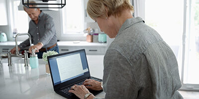 A woman sits in front of a laptop, as Nissen and Associates helps her clean up her QuickBooks account online