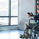 Man in wheelchair in a commercial building looks out a window