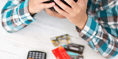 Man holding head in hands looking at Bad business credit score