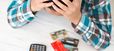 Man holding head in hands looking at Bad business credit score