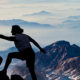 one person standing on a mountain helping another person up. Nissen and Associates Tax and Accounting