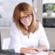 A woman sitting behind her desk, speaks to her client about how his Mortgage Insurance Premium Deduction has been Retroactively Extended.