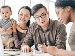 A couple with baby in arms works next to a tax expert to determine if they have to file a tax return