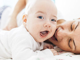 A mother and her baby lay down on a bed excited that the Childbirth And Adoption Penalty Exception was Added