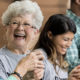 A elderly woman laughs as she talks to a friend about the New Twist Added To The IRA-To-Charity Provision