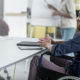 A man in a wheelchair sits at a desk reading about how Congress Extends Employers' Hiring Tax Credit For Another Year