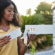 A woman stands at her mailbox holding an IRS letter wondering IRS if it's a Tax Scam Or Something You Need To Address?