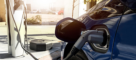 Congress Green-Lights Some Alternative Vehicle Credits, a car sits at the gas pump with a gas pump inserted into the gas tank