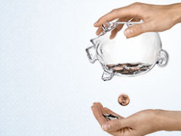 Can't Pay Your Taxes? Payment Due Date Extended Because Of Covid-19. One hand holds a piggy bank upside down dropping a single coin into the other hand.