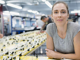 Congress Provides Sick Leave and Child Care Leave Benefits for Employees. A woman looks hopeful as she sits in her office chair on a manafacturing plant