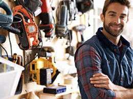 Self-Employed and Independent Contractors Now Qualify for Unemployment Benefits. A man in a flannel shirt stands crossing his arms in a landscaping shop.