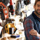 Self-Employed and Independent Contractors Now Qualify for Unemployment Benefits. A man in a flannel shirt stands crossing his arms in a landscaping shop.