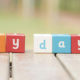 Tax Credit Pays for Keeping Employees on Payroll, P-A-Y-D-A-Y is spelled out in blocks on an outdoor picnic table