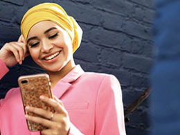 Track Your Economic Impact Payment in The New IRS Portal. A woman looks down engaged with her phone.