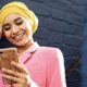 Track Your Economic Impact Payment in The New IRS Portal. A woman looks down engaged with her phone.