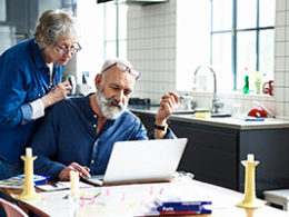 Did You Take Your 2020 RMD Too Soon? An elderly woman peers through her glasses, looking at a laptop screen, while her husband is typing.