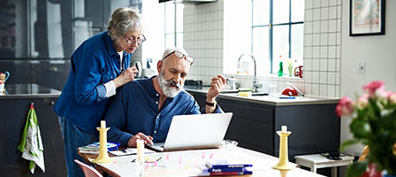 Did You Take Your 2020 RMD Too Soon? An elderly woman peers through her glasses, looking at a laptop screen, while her husband is typing.