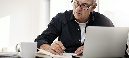 Did You Overlook Something on A Prior Tax Return? A man sits at his home office, overlooking his tax return