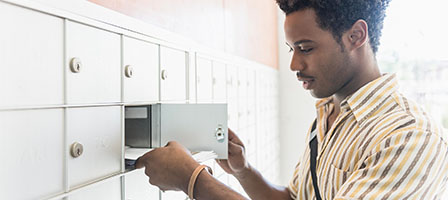 Watch Out: The Treasury Is Sending Some Stimulus Payments by Debit Card - a man looks for a document in his mail box