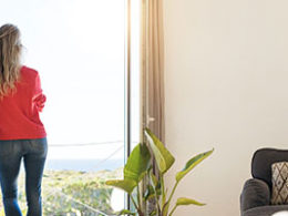 Wealthy Taxpayers May Want to Strategize for Potential Tax Increases, a woman stands by a window of a classy home looking out at the view.