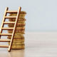 IRS Extends the Opportunity to Defer Capital Gains. A ladder leans against a stack of gold coins