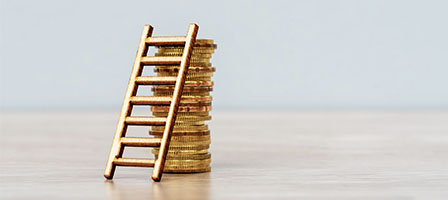 IRS Extends the Opportunity to Defer Capital Gains. A ladder leans against a stack of gold coins