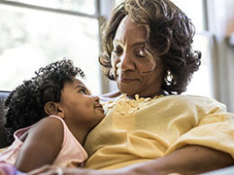 Keeping Your Designated IRA Beneficiary Current Is Important, A older woman warmly smiles down at her granddaughter.