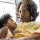 Keeping Your Designated IRA Beneficiary Current Is Important, A older woman warmly smiles down at her granddaughter.