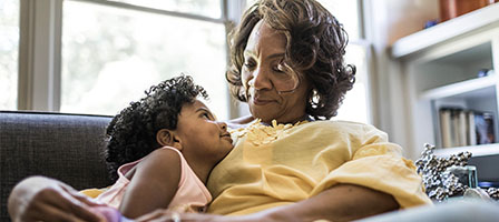 Keeping Your Designated IRA Beneficiary Current Is Important, A older woman warmly smiles down at her granddaughter.