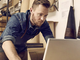 Ready for the 1099-NEC? A man stands over a laptop with a concerned look on his face