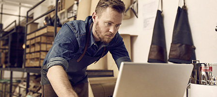 Ready for the 1099-NEC? A man stands over a laptop with a concerned look on his face