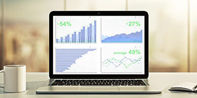 12 Financial Metrics Small Business Owners Should Track - a laptop is open showing positive metrics on spreadsheets with the lines all going up.