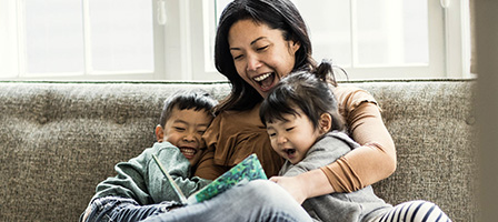 Don't Miss the Opportunity for a Spousal IRA - A woman holds each of her children under her arms while they are all laughing on the couch together