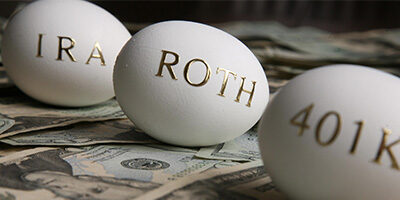 Saving For Retirement? Three golden eggs sit on a desk with IRA, ROTH and 401K written on them.