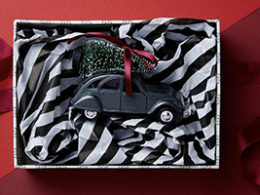 Year-End Gift Giving with Tax Benefits, an ornament sits inside a gift box lined with tissue paper.