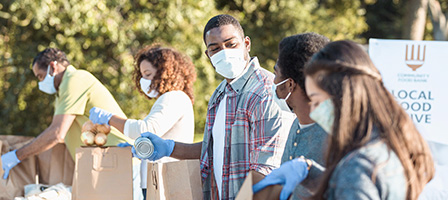 Charitable Contributions Deduction Liberalized For 2021 - A group of masked volunteers help load groceries for charity