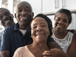 Video: Biden's COVID Relief & Tax Plan. A family of 4 stands together with smiles of gratitude.