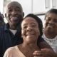 Video: Biden's COVID Relief & Tax Plan. A family of 4 stands together with smiles of gratitude.