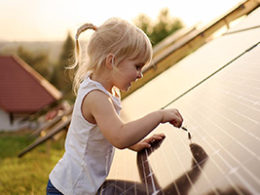 Solar Tax Credit Extended For Two Years, a young girl touches a solar panel