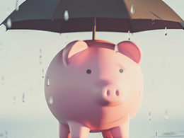 Inflation and Recession: A Double Whammy For Your Finances a piggy bank with an umbrella over it, protecting it from the rain.