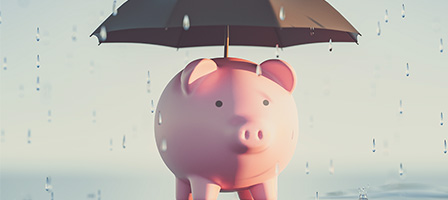 Inflation and Recession: A Double Whammy For Your Finances a piggy bank with an umbrella over it, protecting it from the rain.