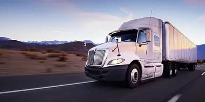 2024 Standard Mileage Rates Announced - a commercial truck driving on a featureless desert highway.