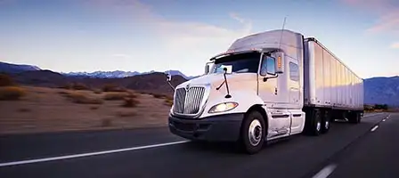 2024 Standard Mileage Rates Announced - a commercial truck driving on a featureless desert highway.