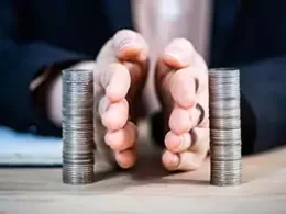 Two hands represent Separating Personal And Business finances by placing them between two separate stacks of coins. effectively dividing them.
