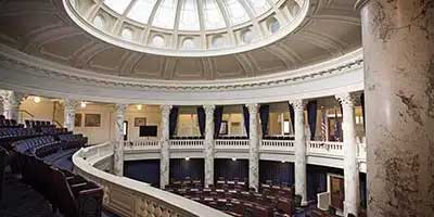 Interior of a classical chamber with a domed ceiling, balcony seating, and ornate columns where Tax Changes for Seniors takes place.
